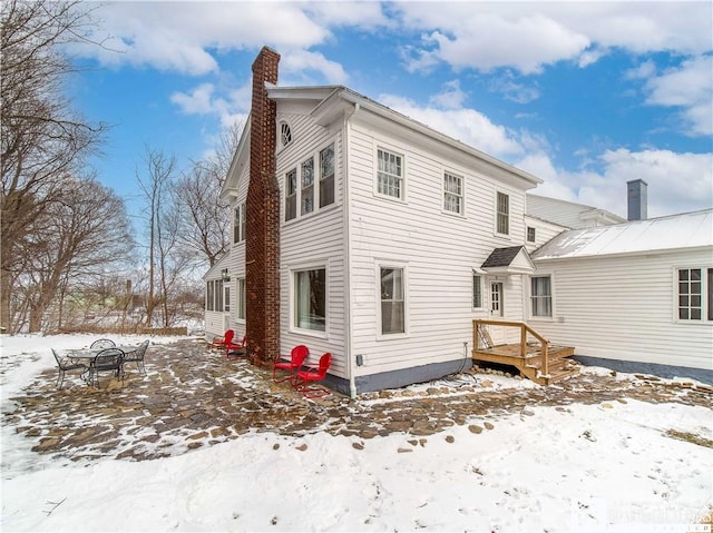 view of snow covered back of property