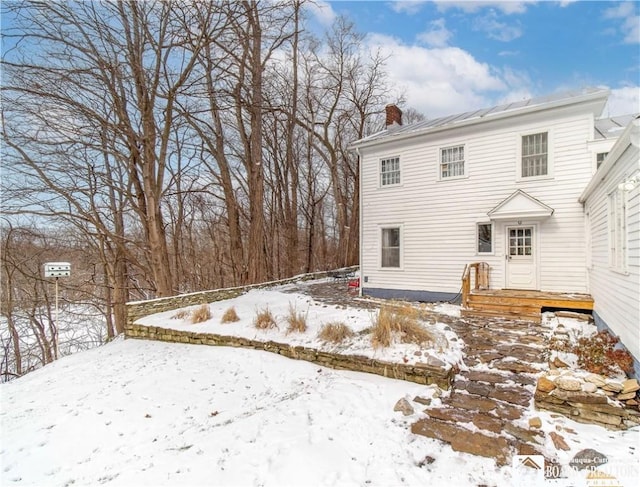 view of snow covered back of property