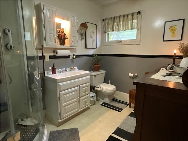 bathroom with vanity, toilet, and a shower with door