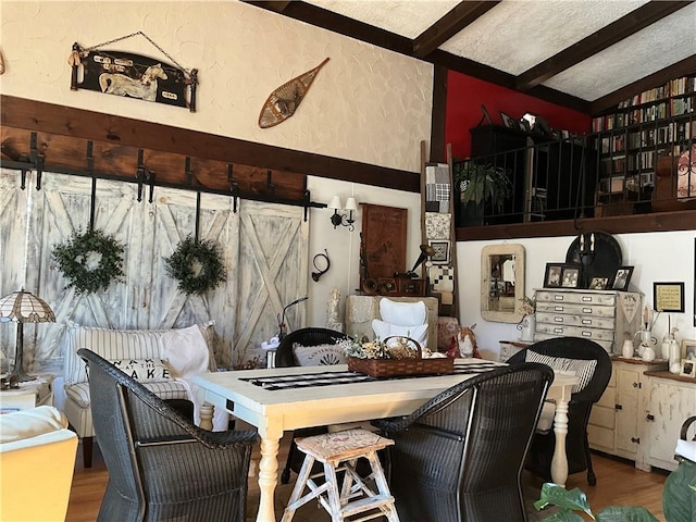 interior space with lofted ceiling with beams, wood-type flooring, and a textured ceiling