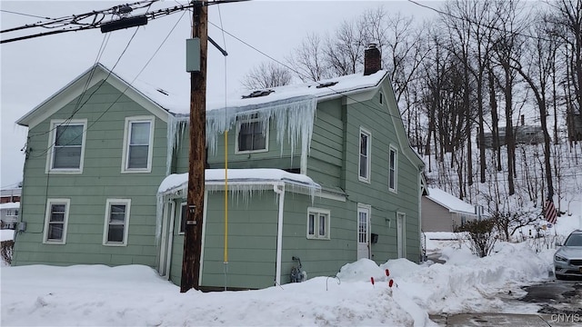 view of snow covered back of property