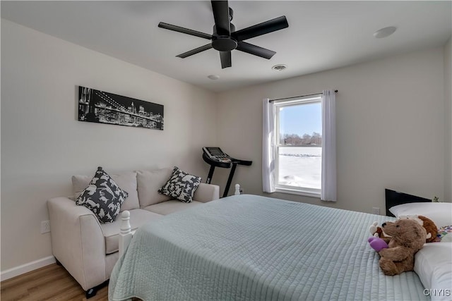 bedroom featuring baseboards, a ceiling fan, light wood-style flooring, and visible vents