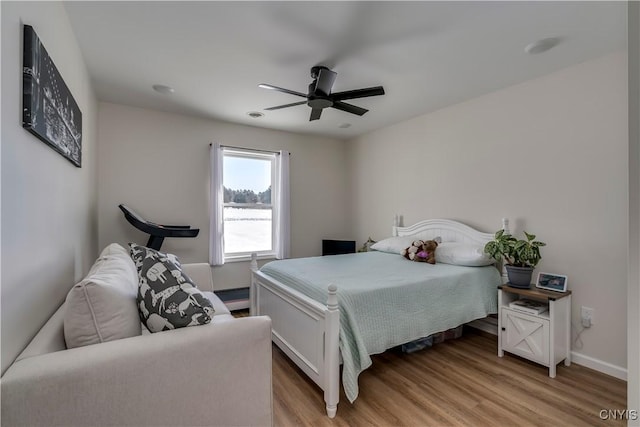 bedroom with baseboards, ceiling fan, and light wood-type flooring