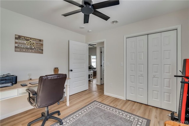 office area featuring light wood-style floors, baseboards, a ceiling fan, and visible vents