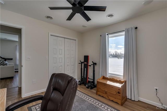 office with baseboards, a ceiling fan, wood finished floors, and visible vents
