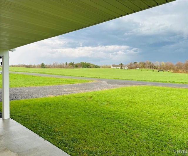 view of community with a lawn and a rural view
