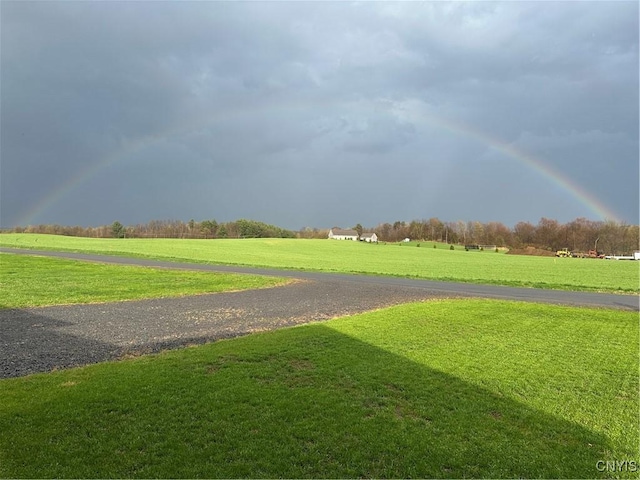 view of property's community with a lawn and a rural view