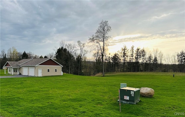 view of yard featuring a garage and driveway