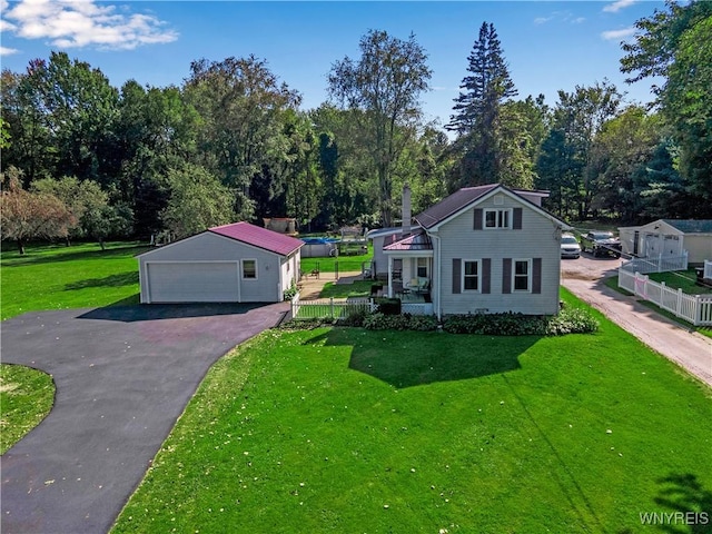 view of front of house with a garage, an outdoor structure, a front yard, and covered porch