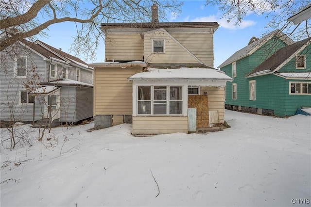 view of snow covered back of property