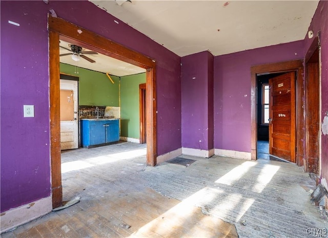 unfurnished living room with ceiling fan and sink