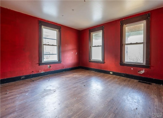 unfurnished room featuring wood-type flooring and a wealth of natural light