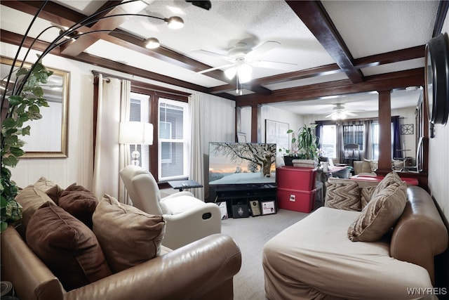 living room with ornate columns, a textured ceiling, carpet flooring, ceiling fan, and beam ceiling