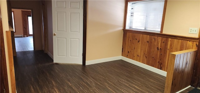 interior space with dark hardwood / wood-style floors and wood walls