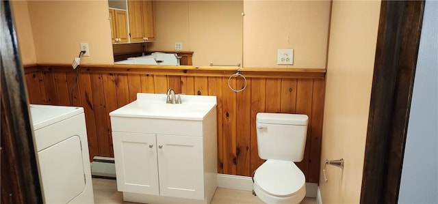 bathroom with vanity, toilet, washer / dryer, and wood walls