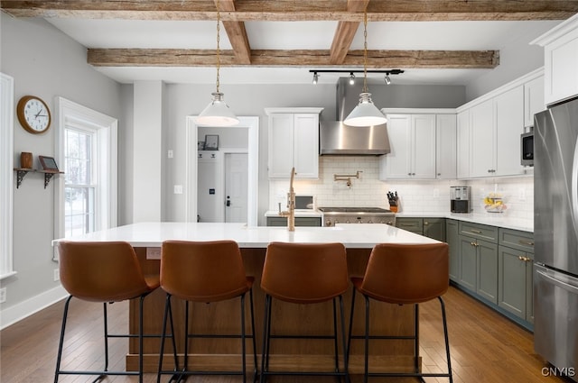 kitchen featuring appliances with stainless steel finishes, decorative light fixtures, beamed ceiling, dark hardwood / wood-style flooring, and decorative backsplash