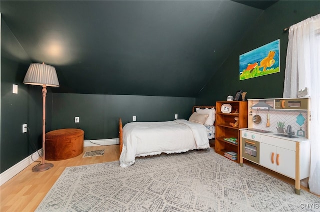 bedroom with lofted ceiling and light hardwood / wood-style flooring