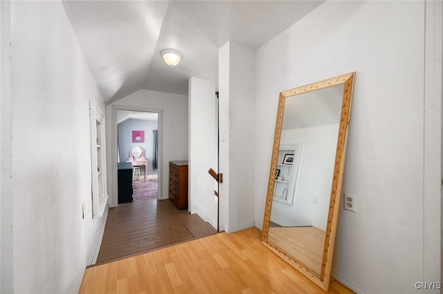 corridor featuring wood-type flooring and lofted ceiling