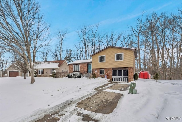 snow covered back of property featuring a storage shed