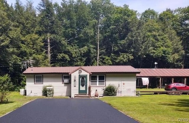 ranch-style home with central AC unit, a front lawn, and a carport