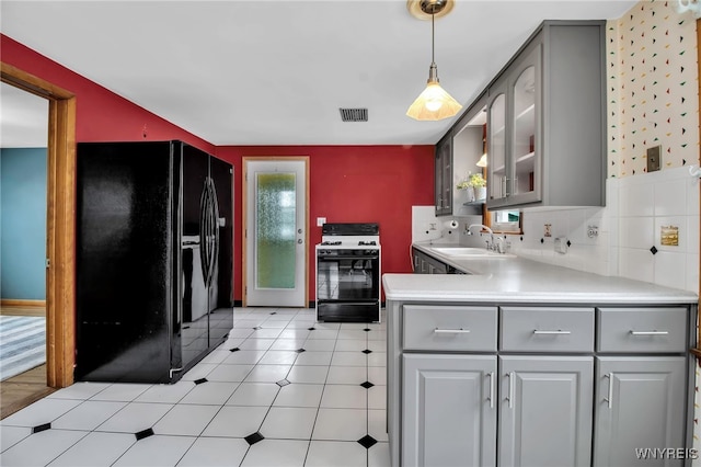 kitchen featuring sink, gray cabinetry, hanging light fixtures, black fridge with ice dispenser, and gas range