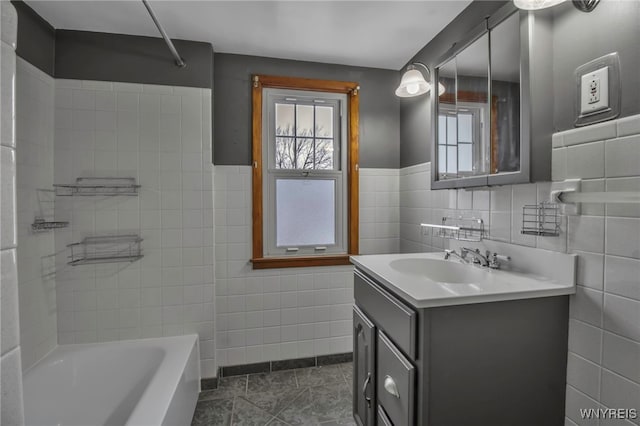 bathroom with tile patterned flooring, vanity, tile walls, and washtub / shower combination