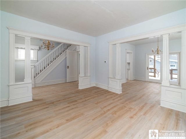 interior space with decorative columns, light wood-type flooring, and a chandelier