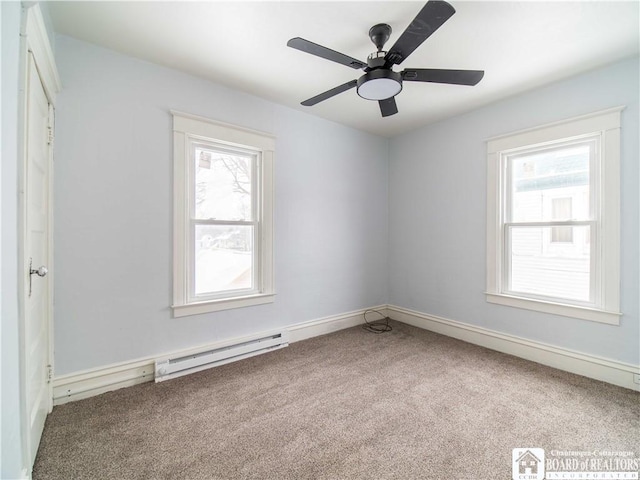 carpeted empty room with ceiling fan, a healthy amount of sunlight, and baseboard heating