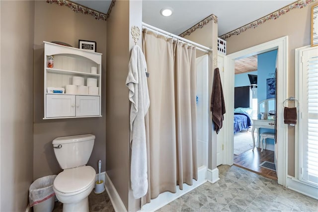 bathroom featuring curtained shower and toilet