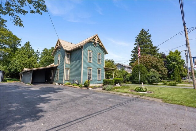 view of front of home featuring a carport and a front lawn