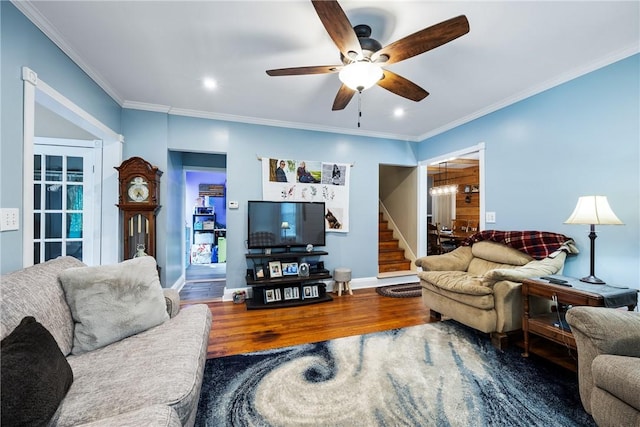 living room featuring wood-type flooring, ornamental molding, and ceiling fan