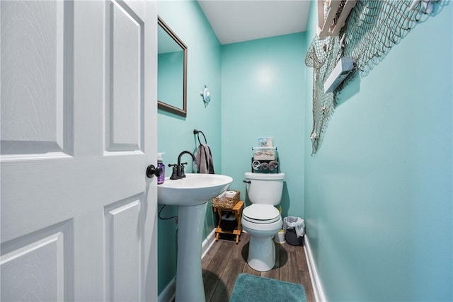 bathroom with hardwood / wood-style floors, sink, and toilet