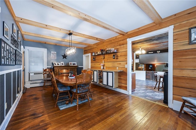 dining area with dark wood-type flooring, a baseboard heating unit, beam ceiling, wooden walls, and a chandelier