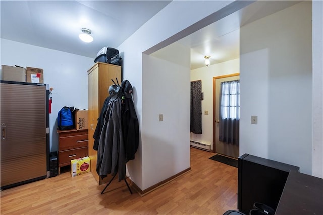 interior space with light wood-type flooring and baseboard heating