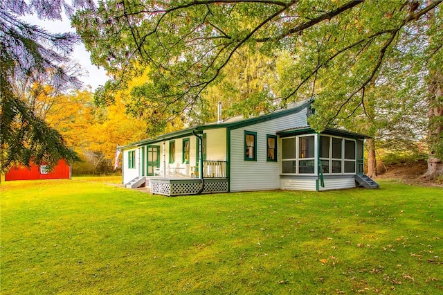 view of side of home with a sunroom and a yard