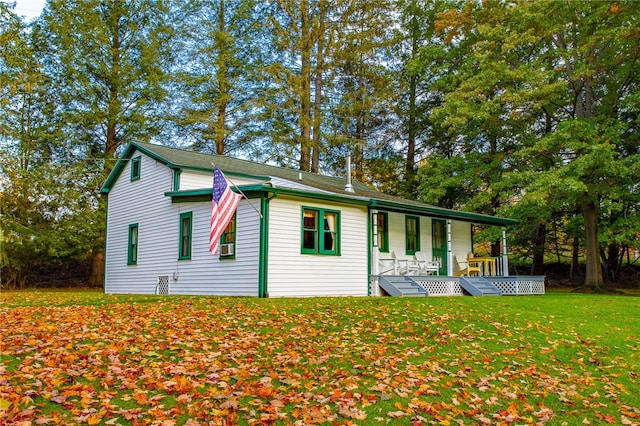 back of property featuring a lawn and covered porch