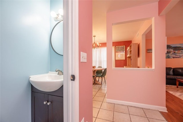 bathroom with tile patterned floors, vanity, and a notable chandelier