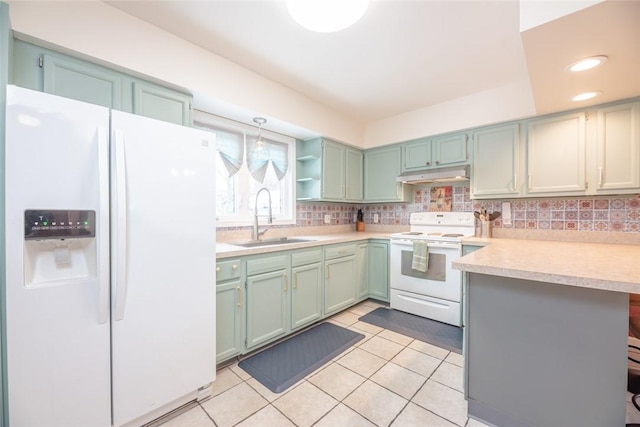 kitchen with hanging light fixtures, sink, light tile patterned floors, and white appliances