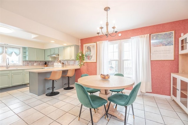 tiled dining room with sink and a chandelier