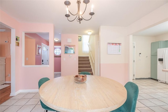 tiled dining room featuring a chandelier