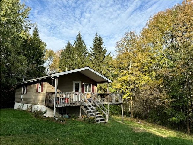 view of front of home with a wooden deck and a front lawn