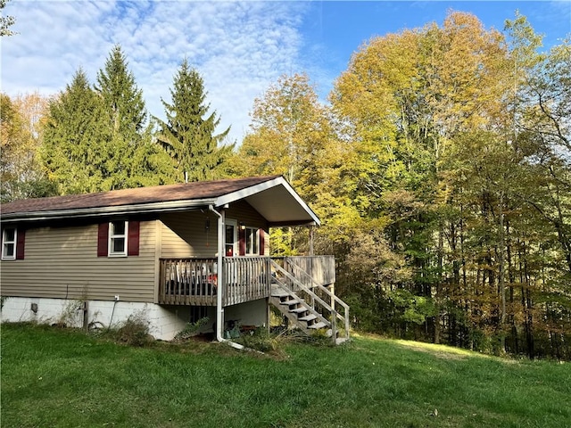 exterior space with a wooden deck and a lawn