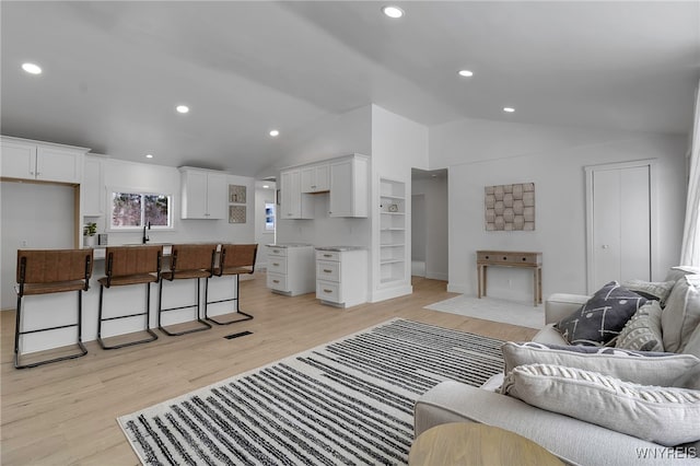 living room featuring light hardwood / wood-style flooring and vaulted ceiling