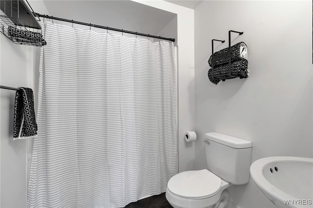 bathroom with a shower with curtain and toilet