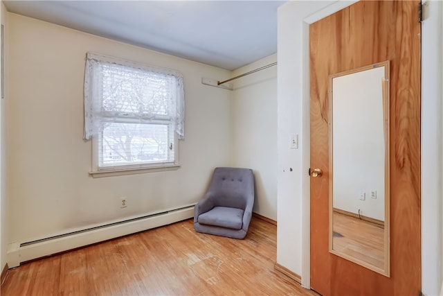 sitting room with baseboard heating and light wood-type flooring