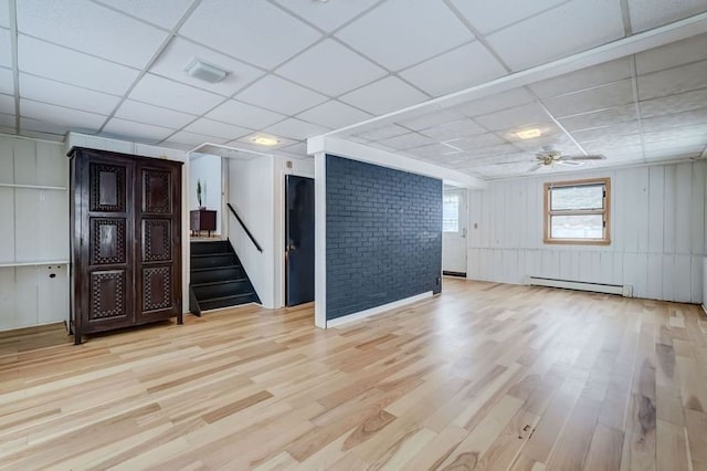 spare room with light hardwood / wood-style flooring, a paneled ceiling, ceiling fan, and baseboard heating