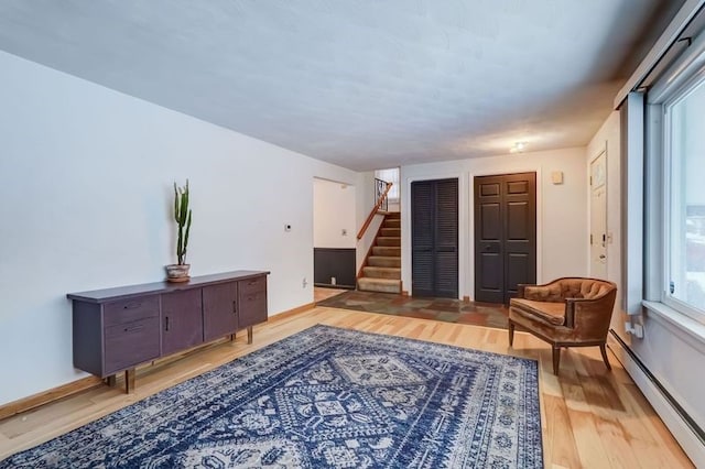 sitting room featuring hardwood / wood-style floors and a baseboard heating unit