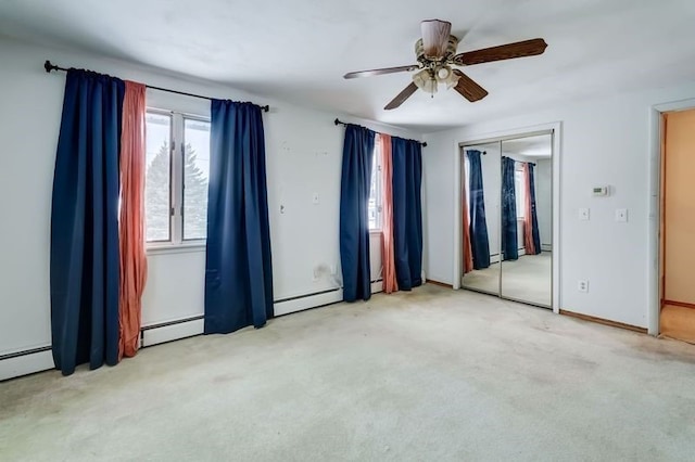 unfurnished bedroom with a baseboard heating unit, light carpet, and ceiling fan