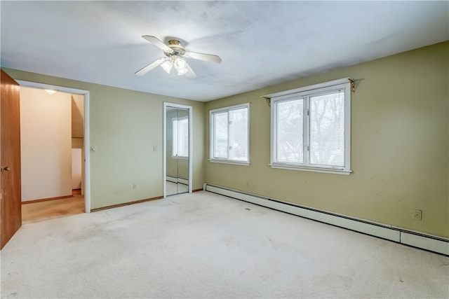 unfurnished bedroom featuring a baseboard heating unit, light colored carpet, and ceiling fan