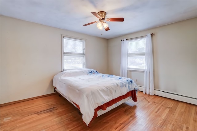 bedroom with multiple windows, wood-type flooring, and ceiling fan